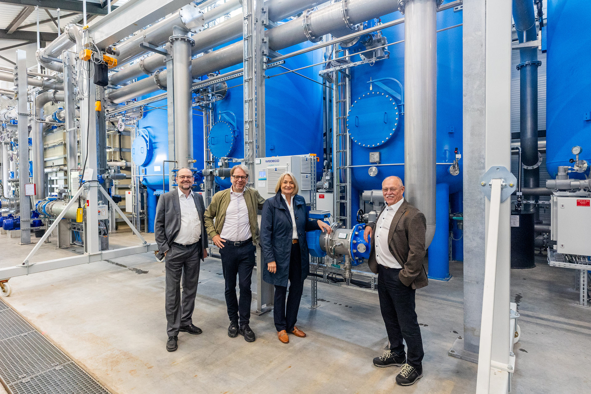 Vier Menschen vor Wasserpumpen